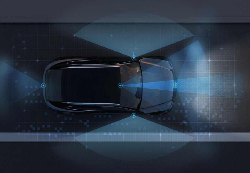 An autonomous vehicle viewed from above, showing the range of its outside sensors