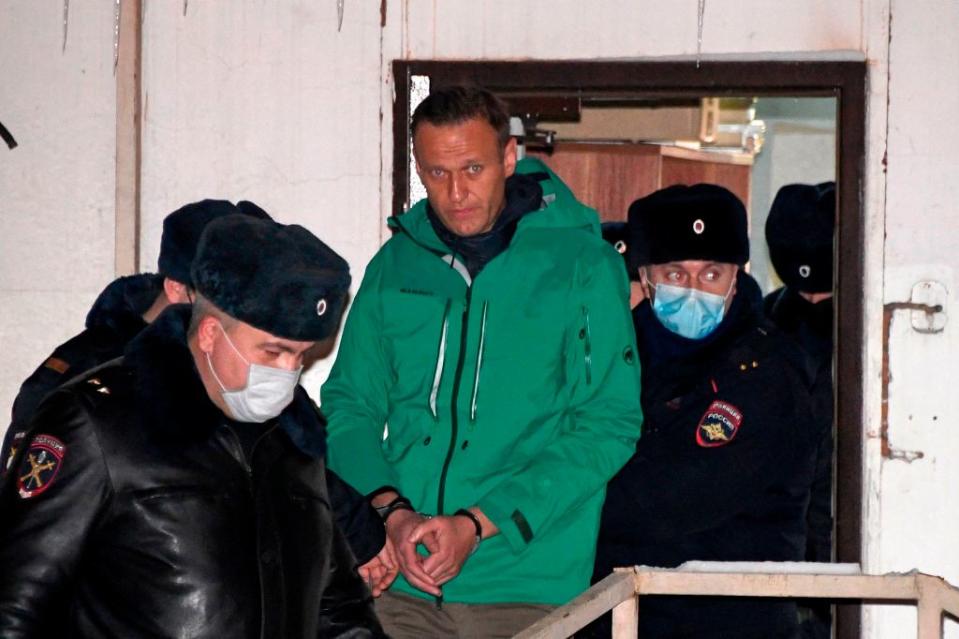 Opposition leader Alexei Navalny is escorted out of a police station on January 18, 2021, in Khimki, outside Moscow, following the court ruling that ordered him jailed for 30 days. - Kremlin critic Alexei Navalny on Monday urged Russians to stage mass anti-government protests during a court hearing after his arrest on arrival in Moscow from Germany. (Photo by Alexander NEMENOV / AFP)<span class="copyright">AFP via Getty Images</span>