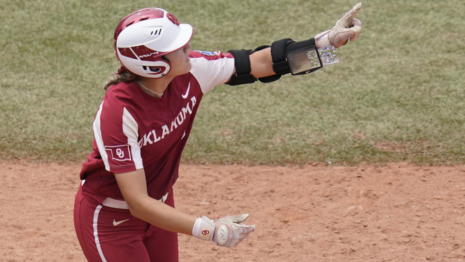 Oklahoma's Kinzie Hansen gestures as she runs toward first base after hitting a home run in the seventh inning against James Madison in an NCAA Women's College World Series softball game Sunday, June 6, 2021, in Oklahoma City. (AP Photo/Sue Ogrocki)