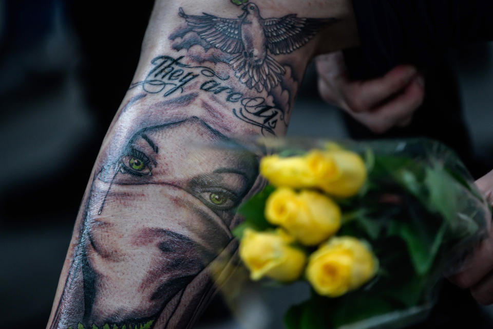 Image: A man shows his freshly inked tattoo of the face of a Muslim woman wearing a face veil with the words 