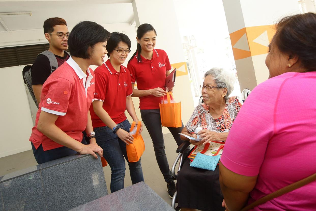 National women's team bowlers Cherie Tan (third from left) and Daphne Tan (fourth from left) distributing masks and hand sanitisers to senior citizens at Clementi Avenue 4. They were joined by Sim Ann (second from left), Senior Minister of State for Culture, Community and Youth. (PHOTO: MCCY)