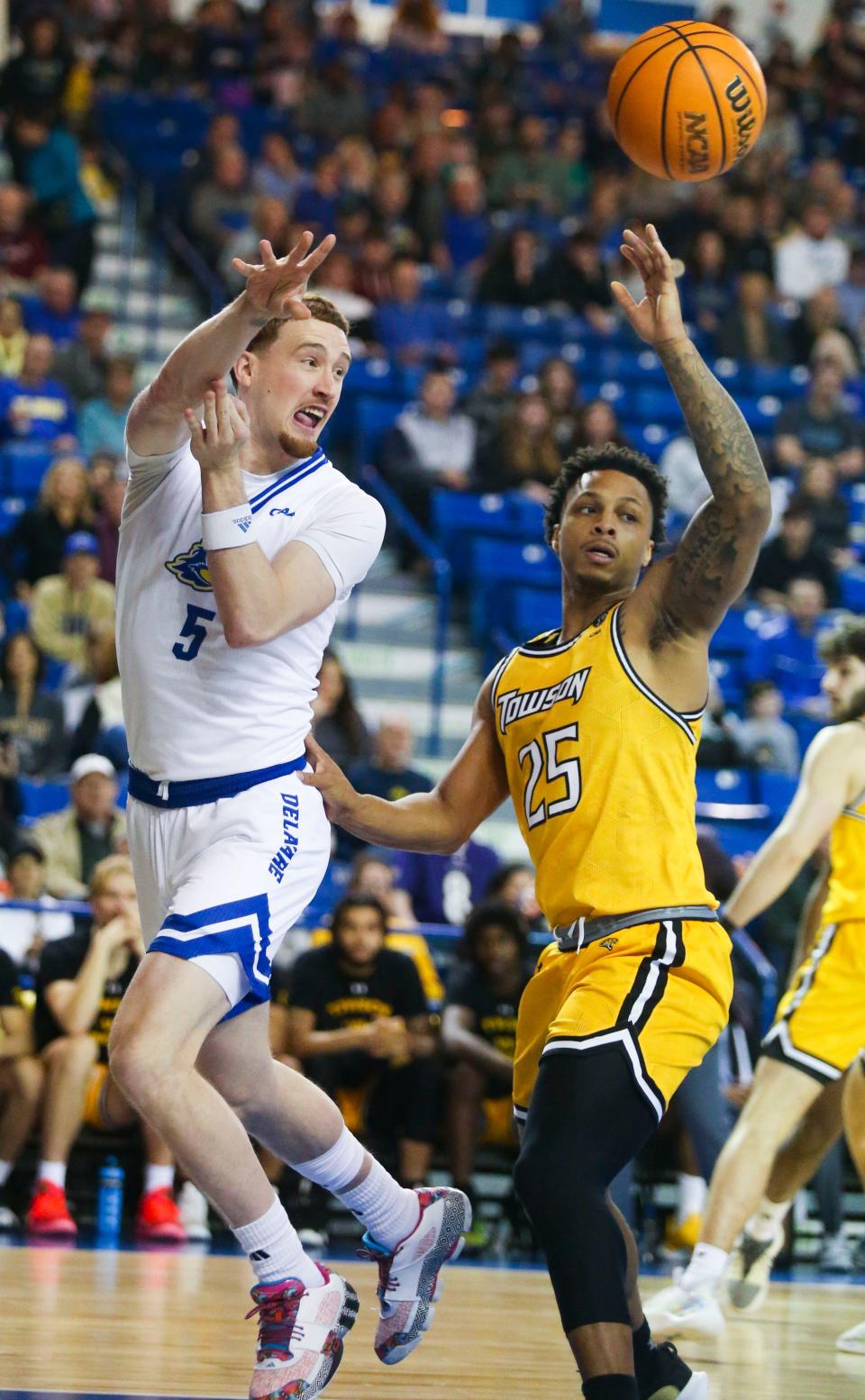 Delaware's Christian Ray (left) passes in front of Towson's Messiah Jones in the first half of Delaware's 67-56 loss at the Bob Carpenter Center, Saturday, Jan. 27, 2024.
