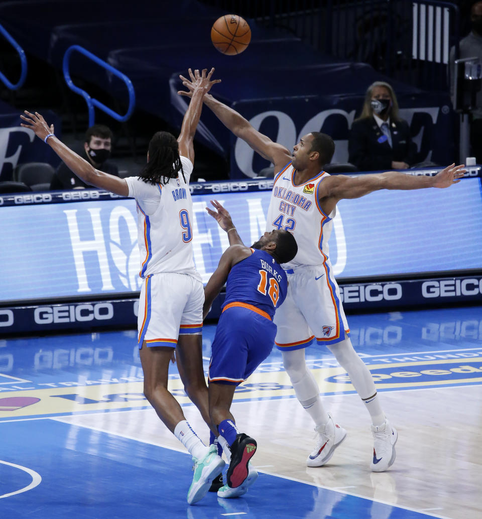 New York Knicks guard Alec Burks (18) goes against Oklahoma City Thunder center Moses Brown (9) and center Al Horford (42) during the first half of an NBA basketball game, Saturday, March 13, 2021, in Oklahoma City. (AP Photo/Garett Fisbeck)