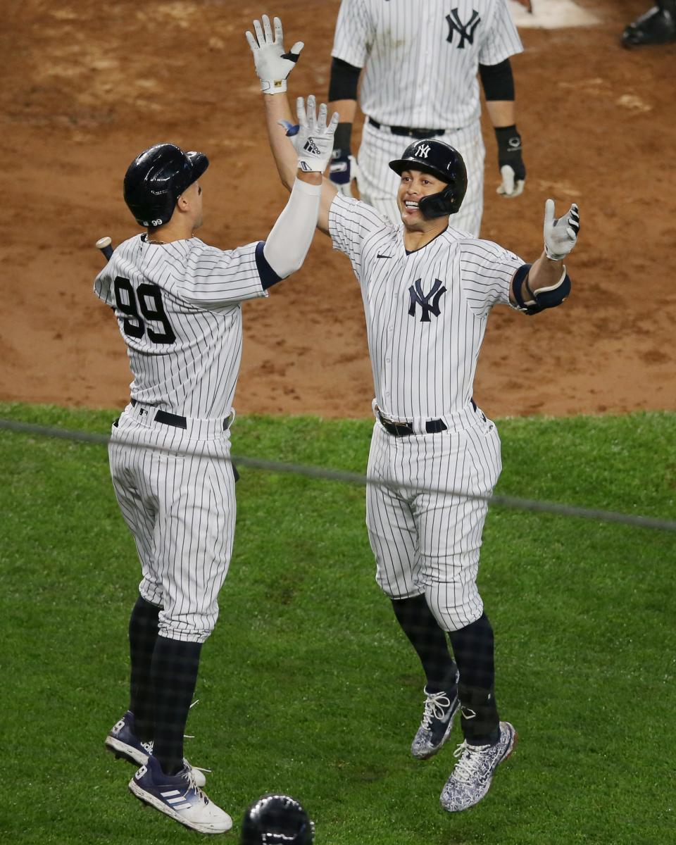 Giancarlo Stanton (right) celebrates his two-run home run against the Astros with teammate Aaron Judge.