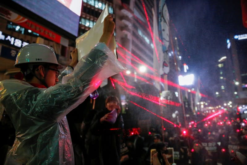 Students and young people point laser pens during a demonstration to support Hong Kong pro-democracy protesters in Seoul