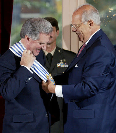 Uruguayan President Tabare Vazquez (L) receives the sash from outgoing President Jorge Batlle, in the Estevez Palace in Montevideo, Uruguay in this March 1, 2005 file picture. REUTERS/Andres Stapff/File Photo