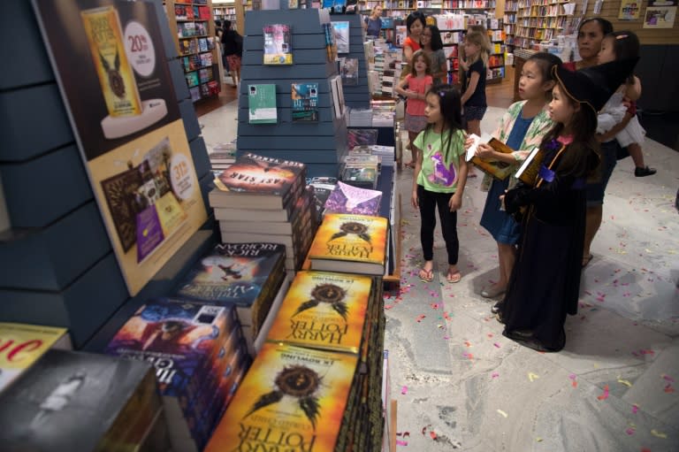 Children watch a video preview at a book store during the launch of the new "Harry Potter and the Cursed Child" in Singapore on July 31, 2016