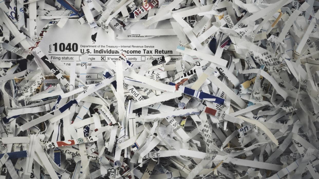  A 1040 US Individual Income Tax Return among heaps of shredded paper. 