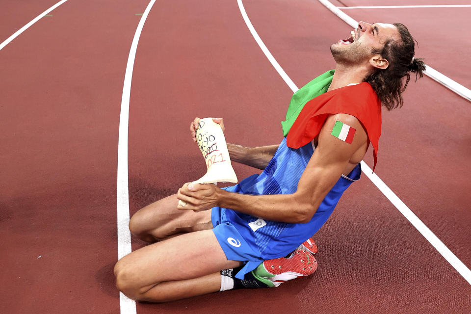 Gold medalist Gianmarco Tamberi of Italy celebrates on the track after jointly winning the final of the men's high jump at the 2020 Summer Olympics, Sunday, Aug. 1, 2021, in Tokyo, Japan. (Cameron Spencer/Pool Photo via AP)