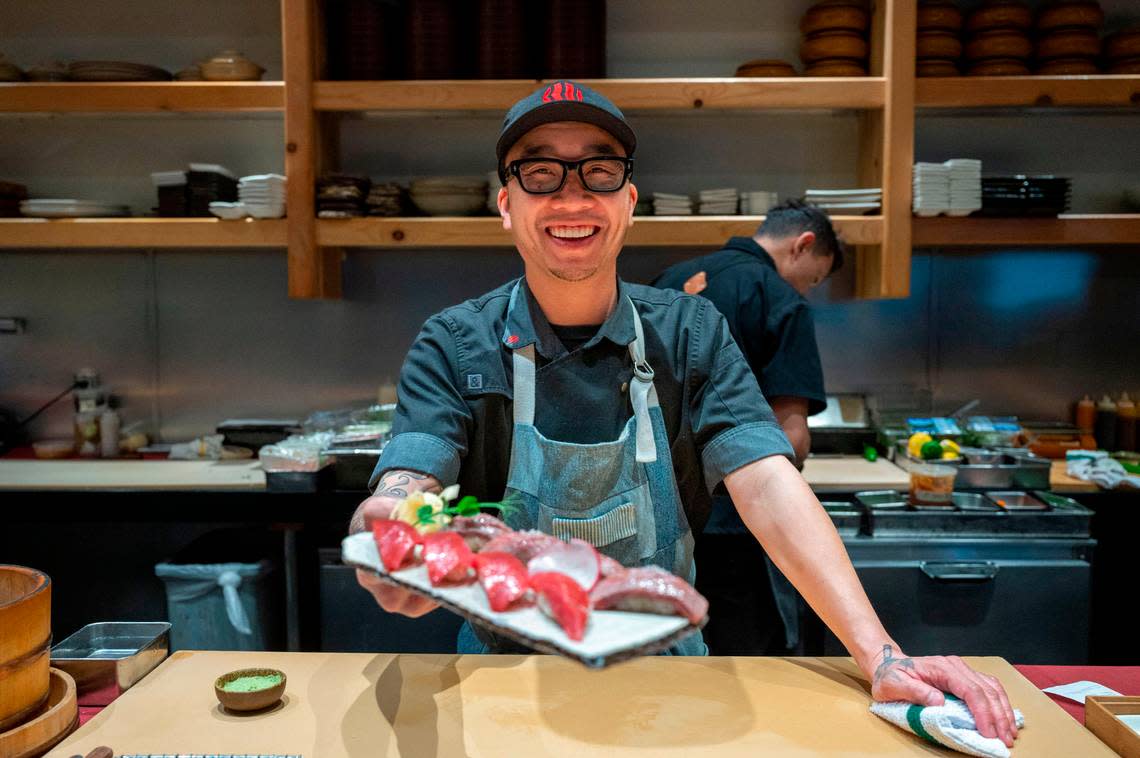 Kru Contemporary Japanese Cuisine chef and co-owner Billy Ngo holds up a plate of sushi Friday. Ngo was named a semifinalist for the James Beard Award.