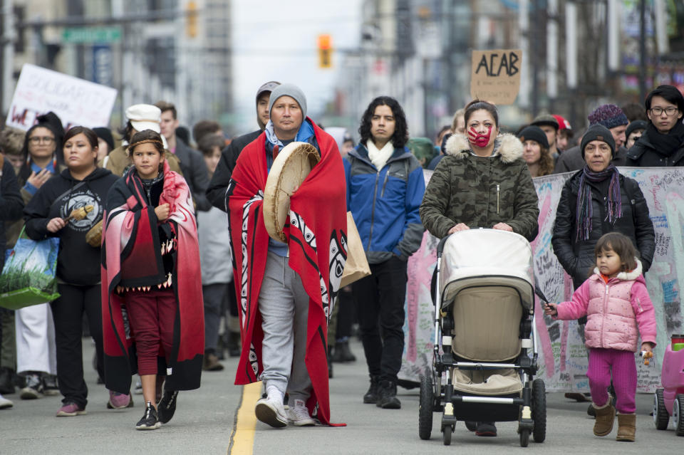 Protesters walk down Granville Street in downtown Vancouver, British Columbia, Wednesday, Feb. 12, 2020. The protesters are standing in solidarity with the Wet'suwet'en hereditary chiefs opposed to the LNG pipeline in northern British Columbia. (Jonathan Hayward/The Canadian Press via AP)