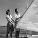 <p>Senator John F. Kennedy of Massachusetts is shown with his fiancee, Jacqueline Bouvier, as the couple adjusts the rigging on a boat during a vacation at the Kennedy compound in Hyannis Port, Massachusetts.</p>