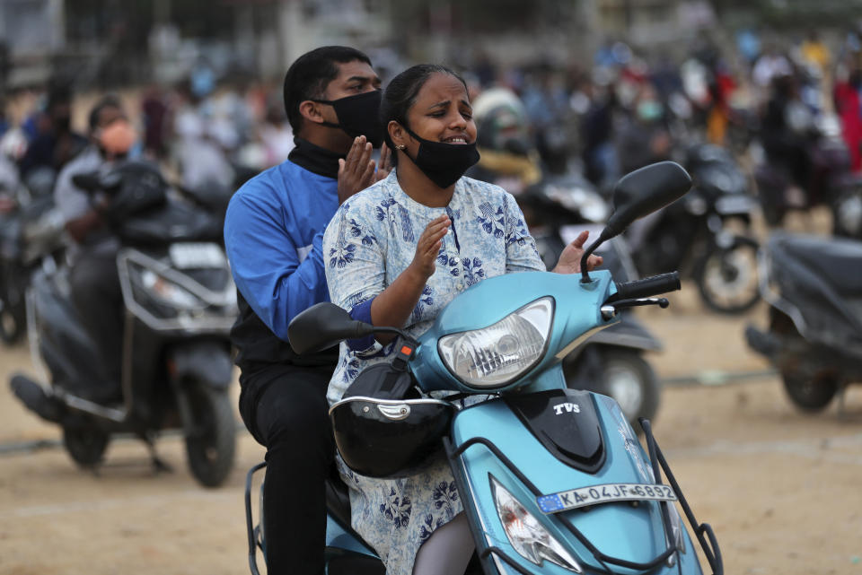 Faithful sit on their two-wheelers and pray as they attend a drive-in mass in an open area of Bethel AG Church as part of maintaining social distancing to prevent the spread of coronavirus in Bengaluru, India, Sunday, June 21, 2020. India is the fourth hardest-hit country by the COVID-19 pandemic in the world after the U.S., Russia and Brazil. (AP Photo/Aijaz Rahi)