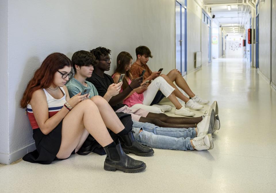 Teens can access cellphones during the school day. <a href="https://www.gettyimages.com/detail/photo/students-killing-time-in-corridor-between-classes-royalty-free-image/1411412809?phrase=teens%20iphones%20school&adppopup=true" rel="nofollow noopener" target="_blank" data-ylk="slk:Rafa Fernandez Torres via Getty Images;elm:context_link;itc:0;sec:content-canvas" class="link ">Rafa Fernandez Torres via Getty Images</a>