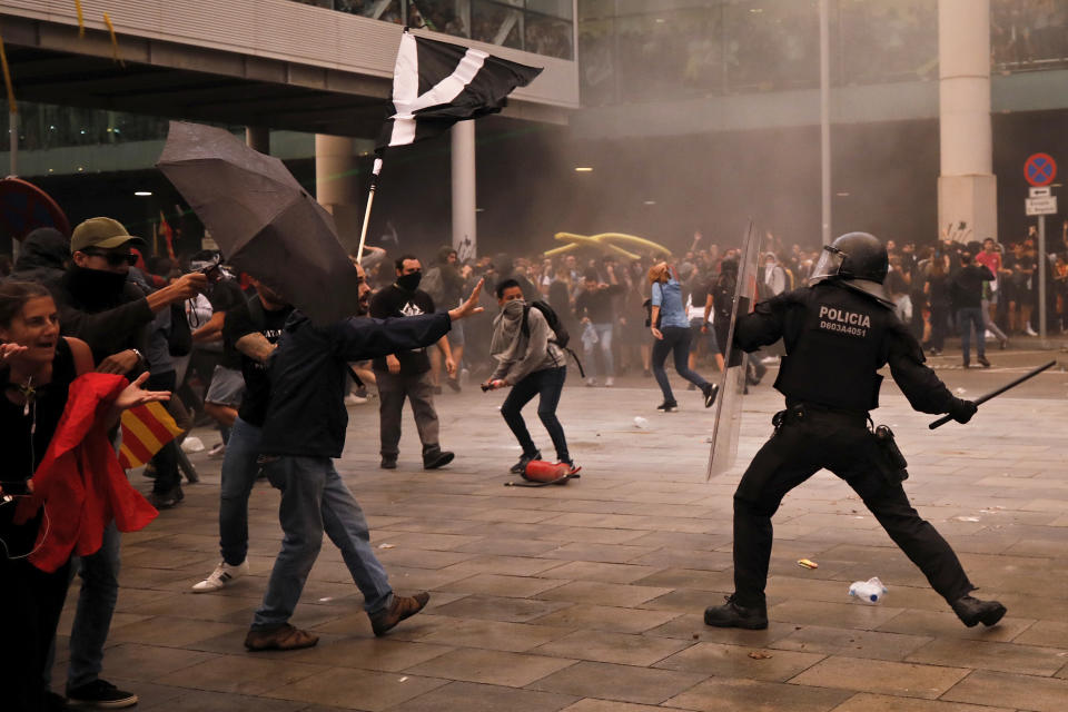 Riot policemen clash with protestors outside El Prat airport in Barcelona, Spain, Monday, Oct. 14, 2019. Riot police have charged at protesters outside Barcelona's airport after the Supreme Court sentenced 12 prominent Catalan separatists to lengthy prison terms for their roles in a 2017 push for the wealthy Spanish region's independence. (AP Photo/Emilio Morenatti)