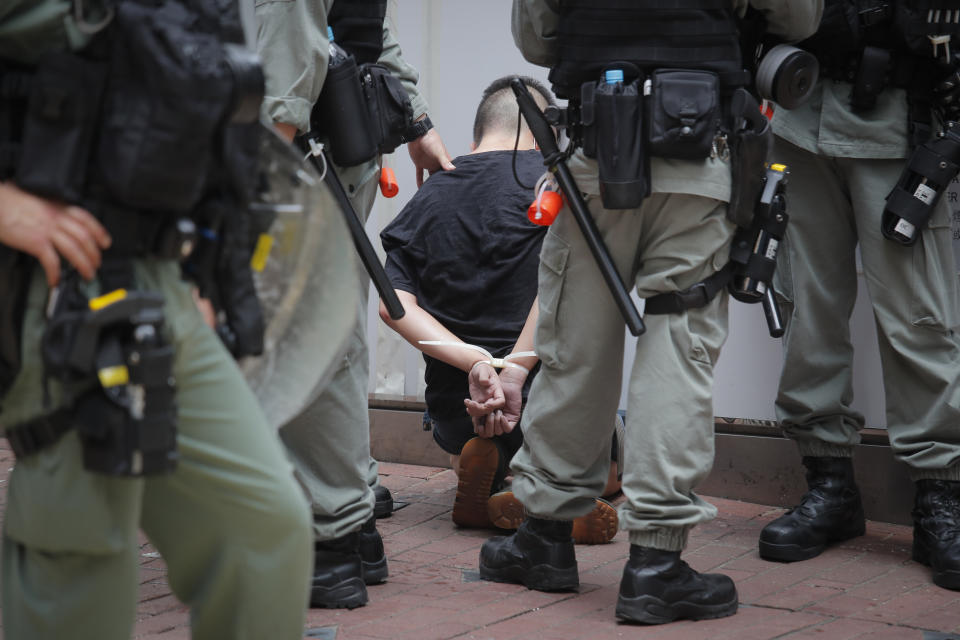 Police detain a protester after being sprayed pepper spray during a protest in Causeway Bay before the annual handover march in Hong Kong, Wednesday, July 1, 2020. Hong Kong marked the 23rd anniversary of its handover to China in 1997, and just one day after China enacted a national security law that cracks down on protests in the territory. (AP Photo/Kin Cheung)