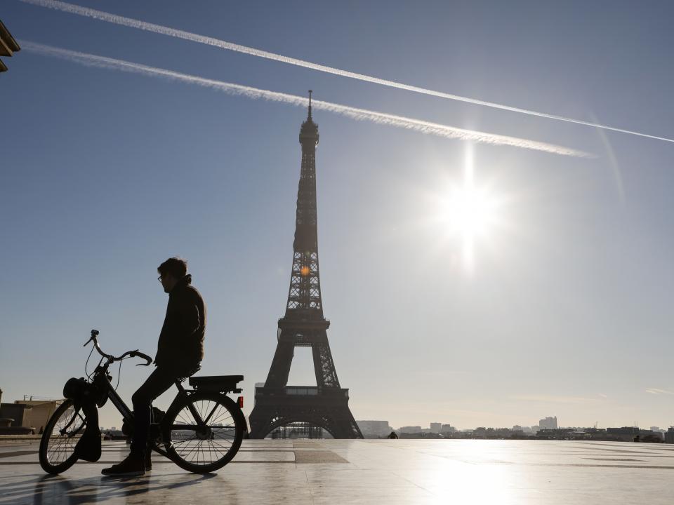 A man rides an electric bike in front of the Eiffel Tower during France’s second coronavirus lockdown (AFP via Getty Images)