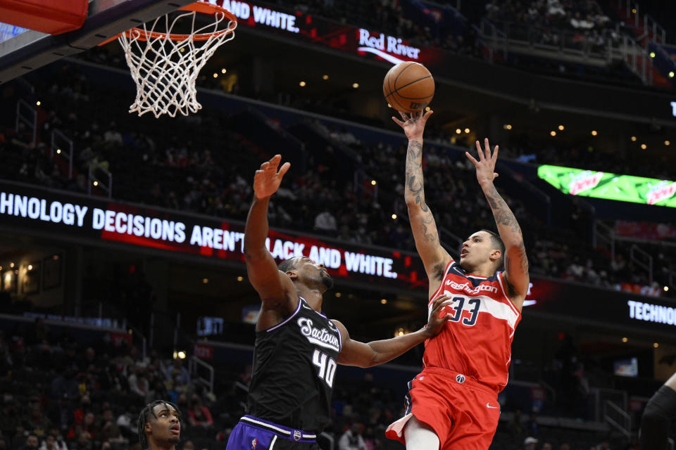 Washington Wizards forward Kyle Kuzma (33) shoots against Sacramento Kings forward Harrison Barnes (40) during the first half of an NBA basketball game Saturday, Feb. 12, 2022, in Washington. (AP Photo/Nick Wass)