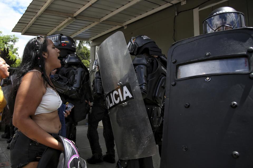 Inmates' relatives confront police outside a prison where there was a deadly fire in Tulua, Colombia, Tuesday, June 28, 2022. Authorities say at least 51 people were killed after the fire broke out during what appeared to be an attempted riot early Tuesday. (AP Photo/Andres Quintero)