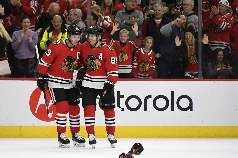 Chicago Blackhawks' Patrick Kane (88) celebrates with teammate Jonathan Toews (19) after scoring a hat trick during the third period of an NHL hockey game against the Minnesota Wild, Sunday, Dec. 15, 2019, in Chicago. (AP Photo/Paul Beaty)