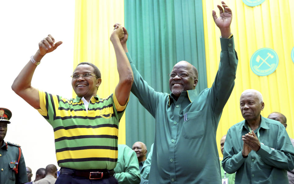 FILE - In this Sunday, July 12, 2015 file photo, Tanzania's public works minister John Magufuli, right, celebrates with president Jakaya Kikwete, left, after the ruling party announced Magufuli as its presidential candidate, in Dodoma, Tanzania. President John Magufuli of Tanzania, a prominent COVID-19 skeptic whose populist rule often cast his country in a harsh international spotlight, has died aged 61 of heart failure, it was announced Wednesday, March 17, 2021 by Vice President Samia Suluhu. (AP Photo/Khalfan Said, File)