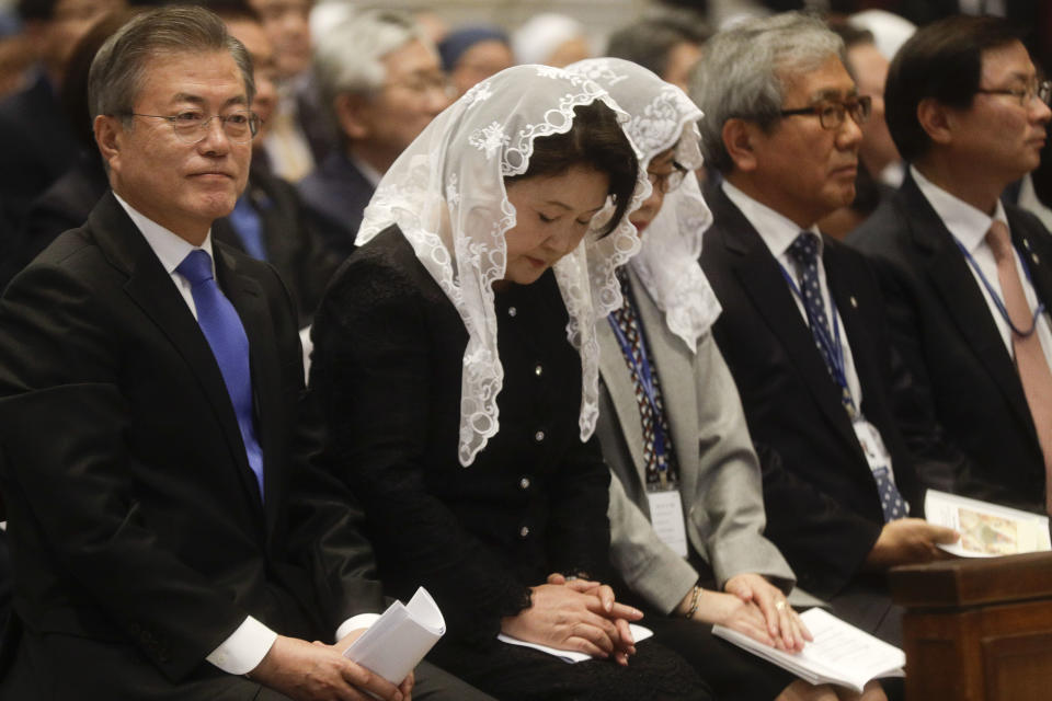 South Korean President Moon Jae-in and his wife Kim Jung-sook, second from left, sit inside St. Peter's Basilica for a Mass for Peace celebrated by Vatican Secretary of State Pietro Parolin at the Vatican, Wednesday, Oct. 17, 2018. South Korea's president is in Italy for a series of meetings that will culminate with an audience with Pope Francis at which he's expected to extend an invitation from North Korean leader Kim Jong Un to visit. (AP Photo/Gregorio Borgia)