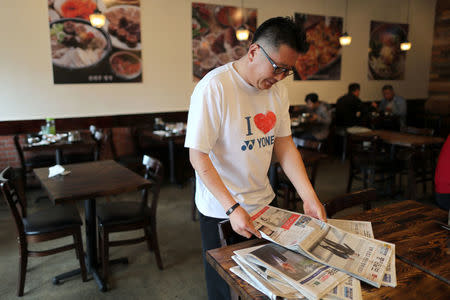 Ki Shin, 47, from South Korea, looks at a newspaper with a front page story about the inter-Korean summit between North Korea’s Kim Jong Un and South Korean President Moon Jae-in, in Koreatown, Los Angeles, California, April 27, 2018. REUTERS/Lucy Nicholson