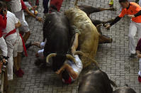 <p>Revellers fall in the middle of fighting bulls from the Nunez del Cuvillo bull ranch during 5th day of the running of the bulls at the San Fermin Festival in Pamplona, northern Spain, July 11, 2018. (Photo: Alvaro Barrientos/AP) </p>