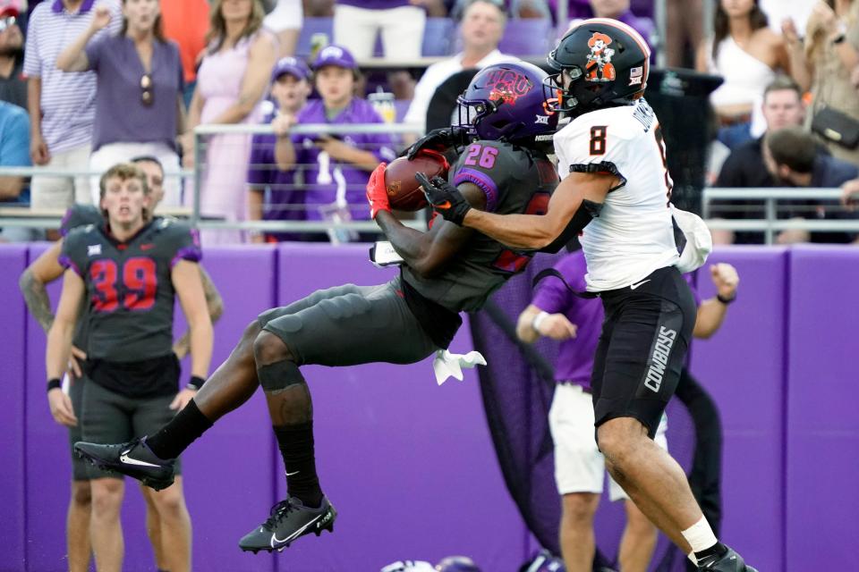 TCU safety Bud Clark (26) makes the interception in front of Oklahoma State wide receiver Braydon Johnson (8) during the second half at Amon G. Carter Stadium.