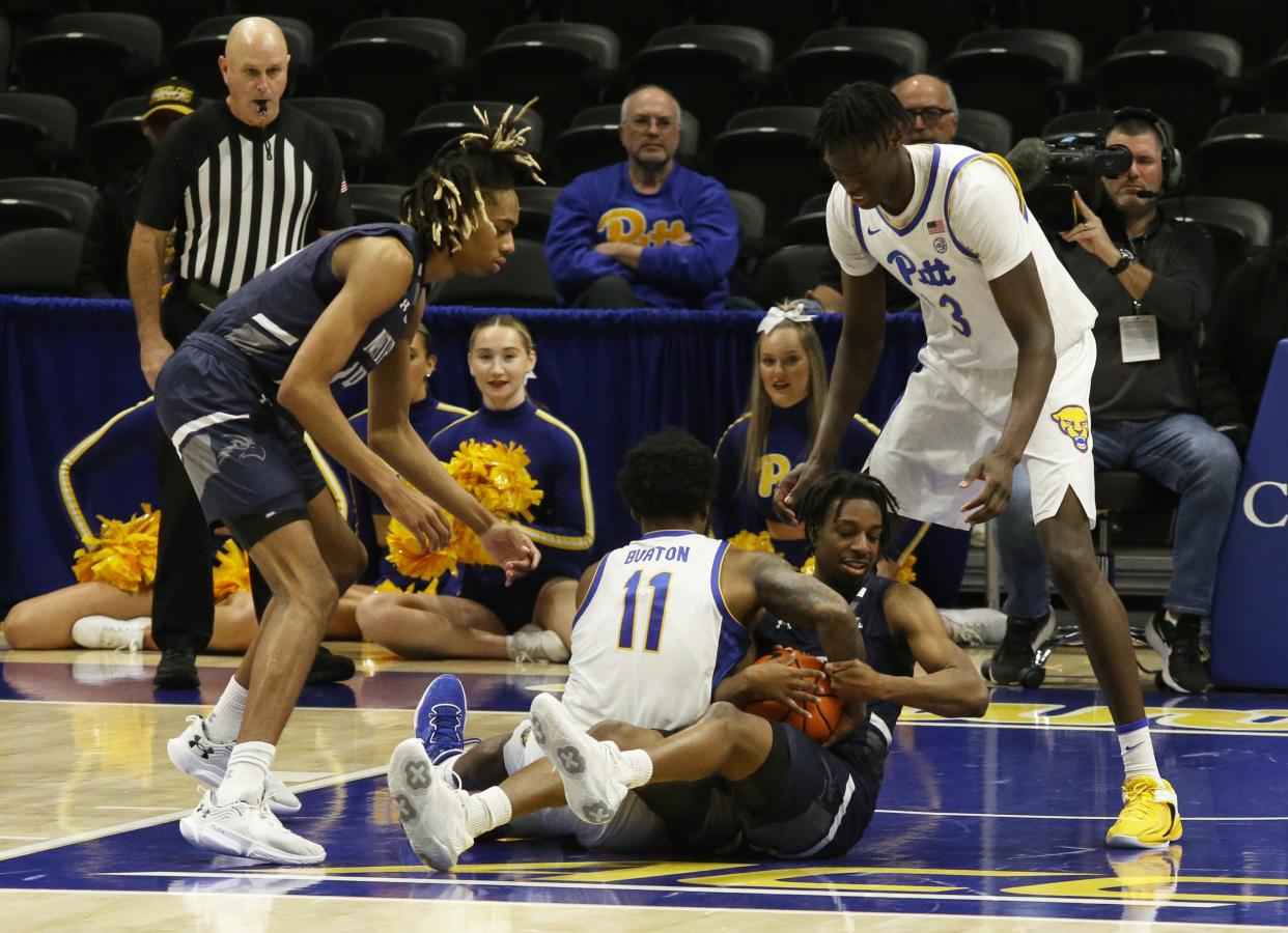 UNF guard Jarius Hicklen (right, bottom) fights Pitt guard Jamarius Burton for a loose ball during Saturday's game at Pittsburgh.