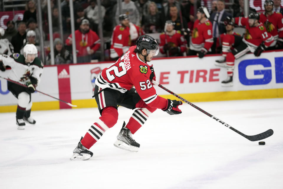 Chicago Blackhawks center Reese Johnson (52) handles the puck during the second period of an NHL hockey game against the Arizona Coyotes, Friday, Jan. 6, 2023, in Chicago. (AP Photo/Erin Hooley)