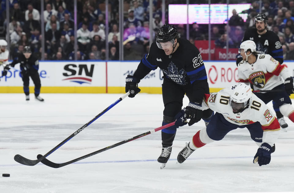 Toronto Maple Leafs defenseman Jake McCabe (22) and Florida Panthers forward Anthony Duclair (10) battle for the puckduring the third period of an NHL hockey game in Toronto on Wednesday, March 29, 2023. (Nathan Denette/The Canadian Press via AP)