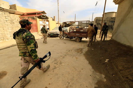 Iraqi soldiers carry weapons during an operation against Islamic State militants in the neighbourhood of Intisar, eastern Mosul, Iraq, December 5, 2016. REUTERS/Thaier Al-Sudani