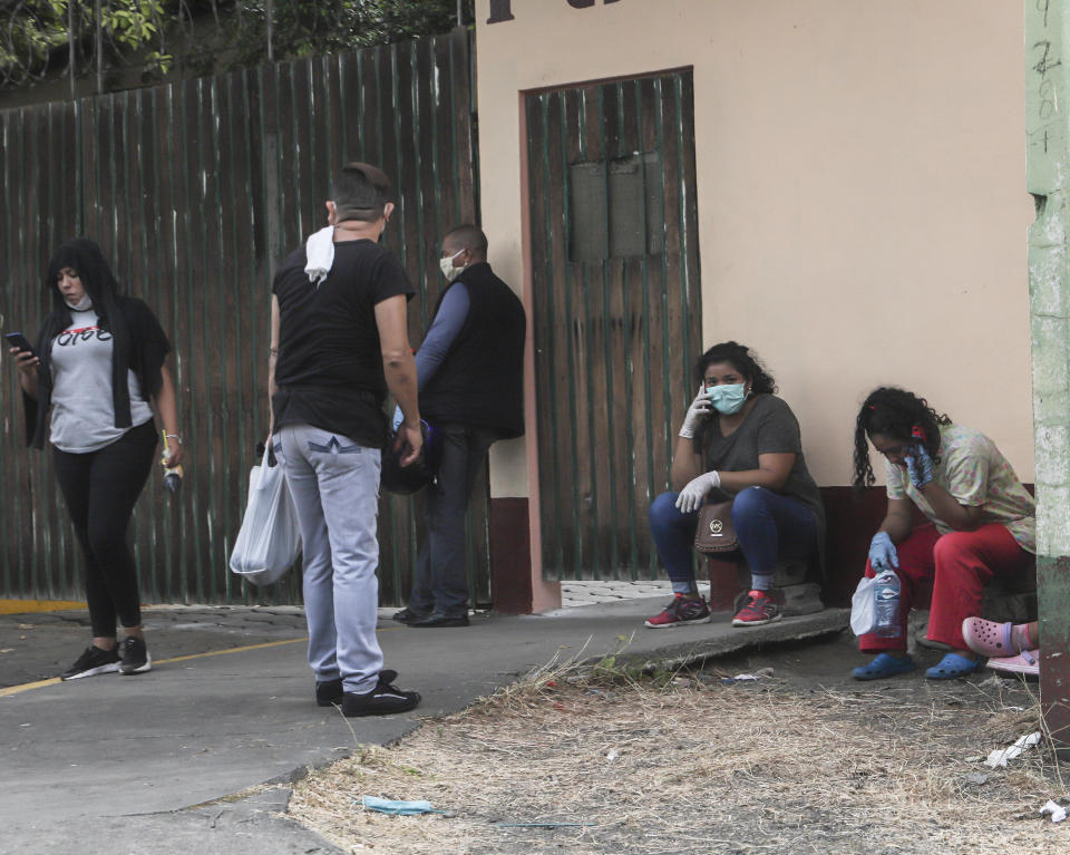 People wearing masks against the spread of the new coronavirus wait outside the Aleman hospital in Managua, Nicaragua, Monday, May 11, 2020. President Daniel Ortega's government has stood out for its refusal to impose measures to halt the new coronavirus for more than two months since the disease was first diagnosed in Nicaragua. Now, doctors and family members of apparent victims say, the government has gone from denying the disease's presence in the country to actively trying to conceal its spread. (AP Photo/Alfredo Zuniga)