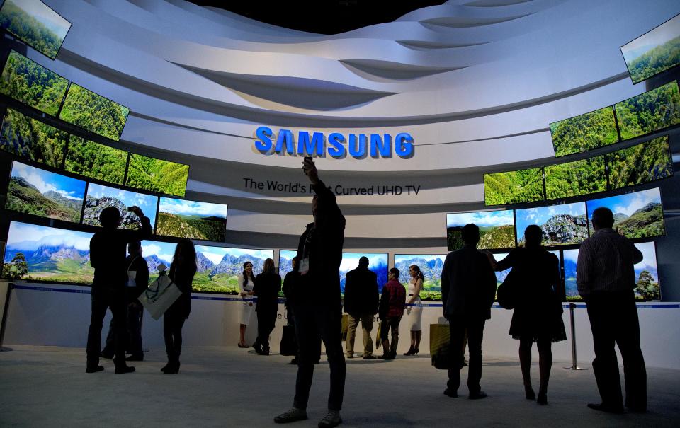 FILE - In this Thursday, Jan. 9, 2014, file photo, trade show attendees take in a display of Samsung curved UHD TVs at the International Consumer Electronics Show, in Las Vegas. Samsung reports quarterly earnings on Friday, Jan. 24, 2014.(AP Photo/Julie Jacobson, File)