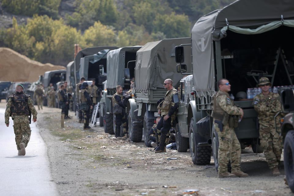 In this photo taken on Sept. 9, 2018, soldiers of NATO-led peacekeeping force KFOR take a break by the side of the road in the village of Kosterc, Kosovo. Serbia's prime minister warned on Wednesday that the formation of a Kosovo army could trigger Serbia's armed intervention in the former province — the bluntest warning so far amid escalating tensions in the Balkans. (AP Photo/Visar Kryeziu)
