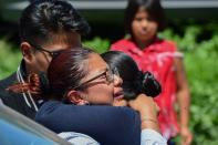 <p>Women embrace at the site of a series of explosions at fireworks warehouses in Tultepec, central Mexico, on July 5, 2018. – At least 17 people were killed, including rescue workers who died saving others’ lives, officials said. The initial explosion occurred around 9:30 am (1430 GMT), then spread to other warehouses just as police and firefighters began attending to the first victims. (Photo: Pedro Pardo/AFP/Getty Images) </p>