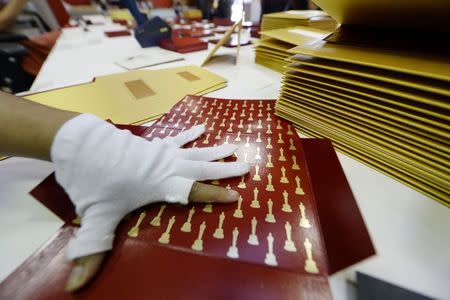 Workers assemble envelopes and announcement award cards bearing the names of Oscar winners for the 87th Academy Awards at Marc Friedland Couture Communications Studio in Los Angeles, California February 12, 2015. REUTERS/Kevork Djansezian