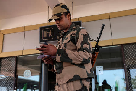 A Border Security Force (BSF) soldier checks the passport of an Indian passenger from the 'friendship bus' between Indian and Pakistan at the Wagah-Attari border crossing, India, March 15, 2019. REUTERS/Alasdair Pal