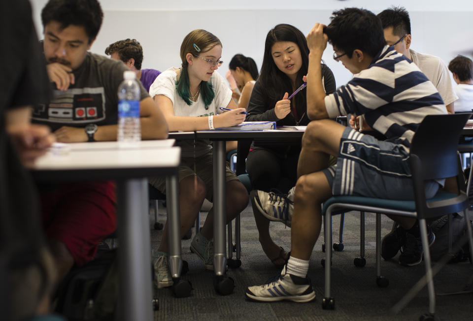 CLAREMONT, CA - OCTOBER 27, 2014: Students Nicole Kyle, Jessica Iwamoto, Daniel Nguyen and Yeahmoon Hong, right (striped shirt), work in a group to problem solve during a chemical and thermal processes class  at Harvey Mudd College on October 27, 2014 in Claremont, California.The student in the class watch lectures online and then work in groups during a live class to problem solve. Professors at Harvey Mudd College are running an experiment to see if students learn better in traditional classes or courses with an on-line element.  (Photo by Gina Ferazzi/Los Angeles Times via Getty Images)