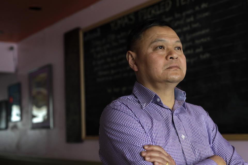 In this Thursday, Feb. 13, 2020, photo, Sai Kyaw, an immigrant from Myanmar, also known as Burma, stands for a photograph in Boston at his restaurant called Yoma. Kyaw said new travel restrictions are preventing his brother, sister and their families from joining him in Massachusetts after nearly a dozen years in the visa application process. (AP Photo/Steven Senne)