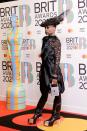 <p>The star wore an all-black ensemble to the BRIT Awards in London. The outfit consisted of a threeASFOUR dress and trouser combination, a hat by Stephen Jones Millinery, Lorraine Schwartz jewellery and Rick Owens shoes. </p>