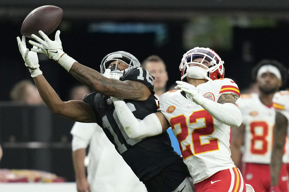 Las Vegas Raiders wide receiver Jakobi Meyers, left, catches a pass against Kansas City Chiefs cornerback Trent McDuffie (22) during the second half of an NFL football game, Sunday, Nov. 26, 2023, in Las Vegas. (AP Photo/John Locher)