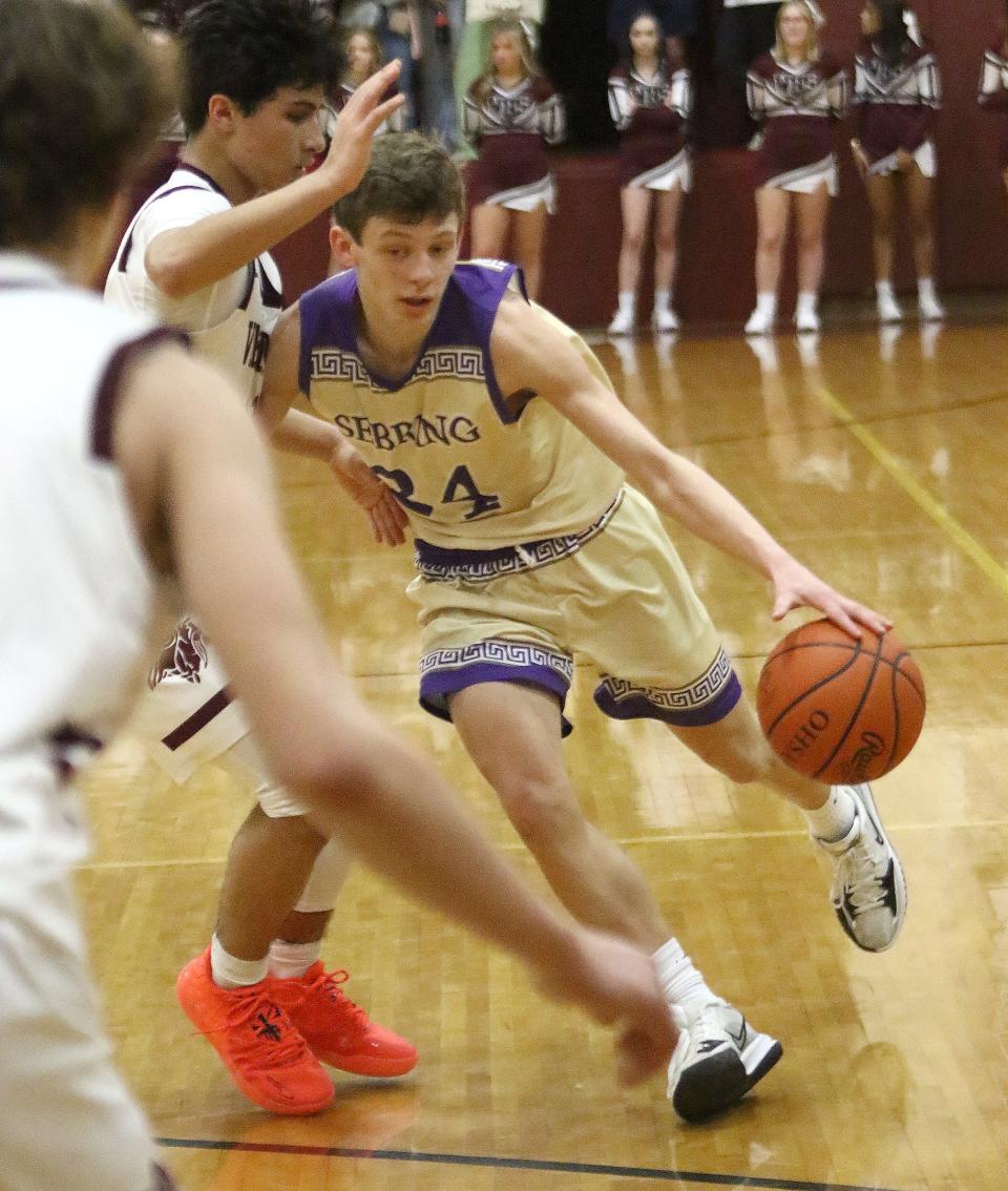 Sebring's Scott Boston, right, drives to the hoop defended by Waterloo's Navarre Alhassan Friday, January 28, 2022.