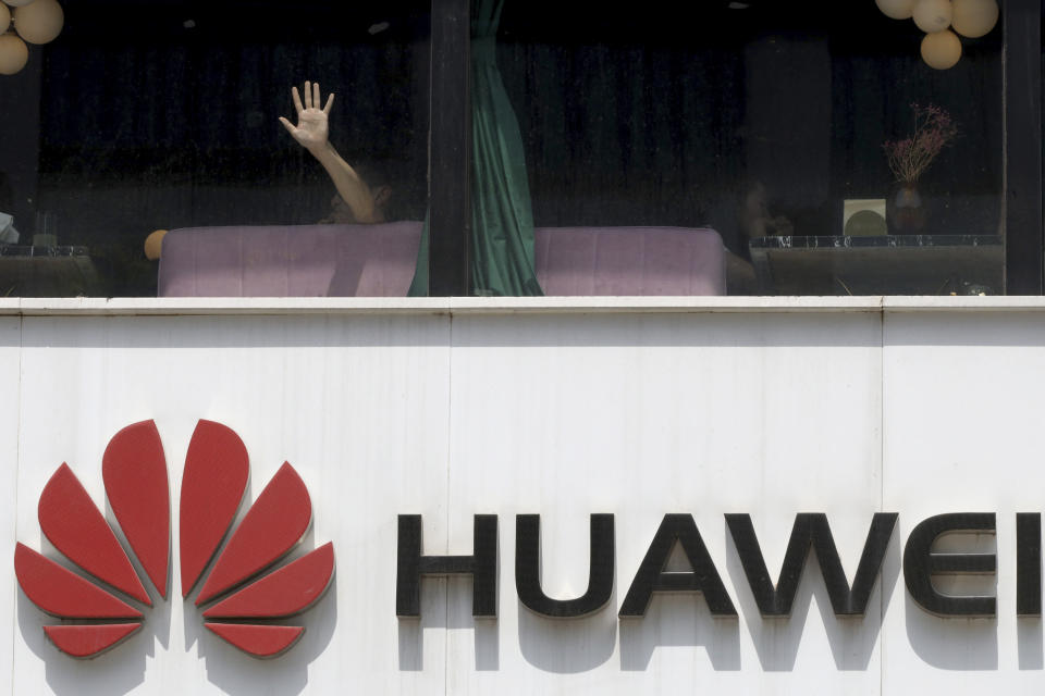 A man presses on the glass window near a logo for Huawei in Beijing on Thursday, May 16, 2019. In a fateful swipe at telecommunications giant Huawei, the Trump administration issued an executive order Wednesday apparently aimed at banning its equipment from U.S. networks and said it was subjecting the Chinese company to strict export controls. (AP Photo/Ng Han Guan)