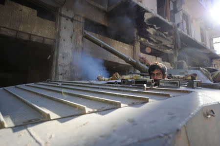 A member of Forces loyal to Syria's President Bashar al-Assad sits inside an armoured vehicle in a government held area of Aleppo, Syria December 9, 2016. REUTERS/Omar Sanadiki