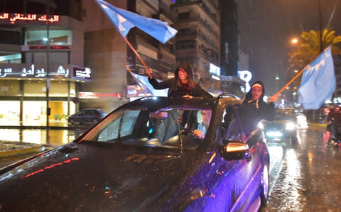 Supporters of Lebanese Prime Minister Saad Hariri wave the Future Movement flags as they celerate in Beirut his return - Credit: AFP