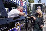 Jill Biden, right, wife of Democratic presidential candidate former vice president Joe Biden, bumps elbows while greeting Teamsters Union member Matt Lortie, of Manchester, N.H., left, during a campaign stop, Wednesday, Sept. 16, 2020, in Manchester. (AP Photo/Steven Senne)