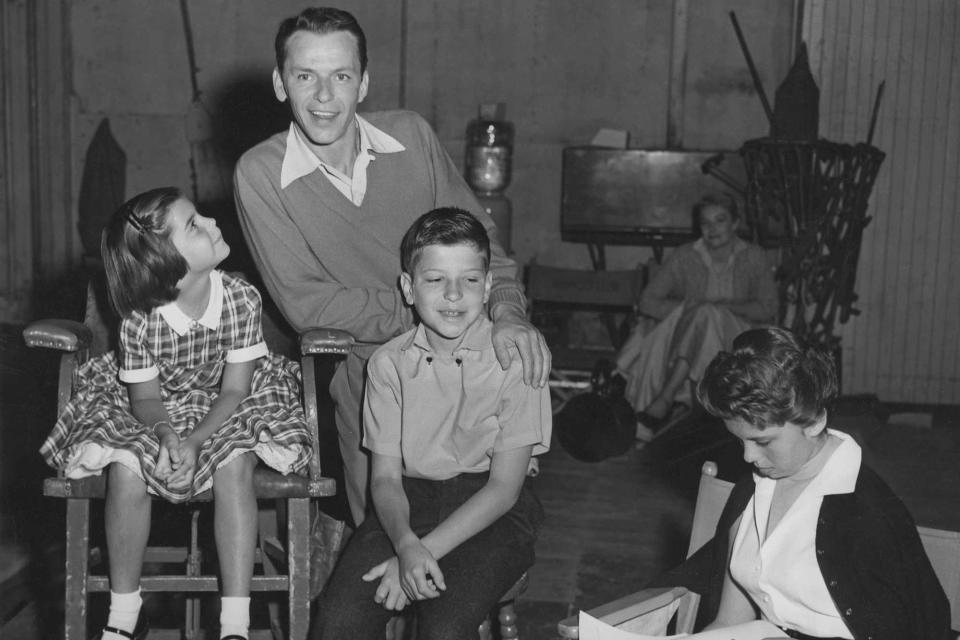 <p>Hulton Archive/Getty</p> Frank Sinatra and his children Christina, Nancy, and Frank Jr. on the set of the film 