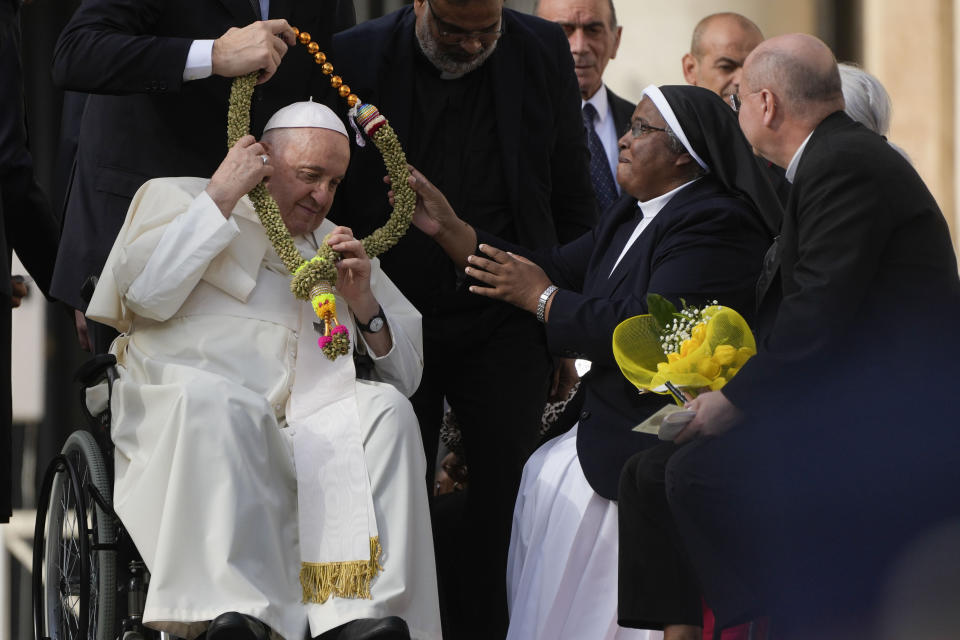 Pope Francis is presented with a gift by faithful during the weekly general audience in St. Peter's Square, at the Vatican, Wednesday, Nov. 15, 2023. (AP Photo/Gregorio Borgia)